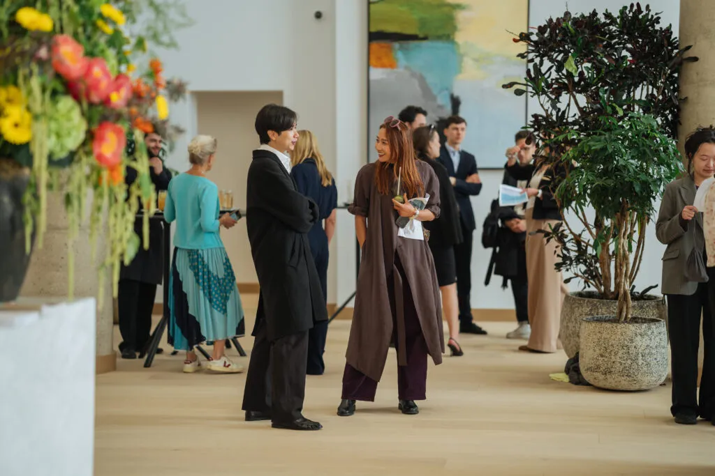 Guests chatting among floral displays in the Herland Gardens entrance lobby.